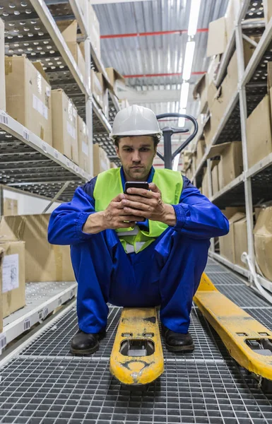 Arbeiter sitzt auf LKW mit Handy — Stockfoto