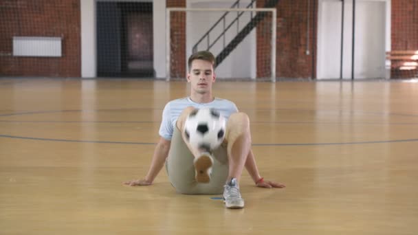 Giovane uomo si esercita con il pallone da calcio — Video Stock