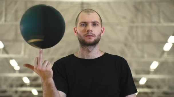 Young man spinning ball on middle finger — Stock Video