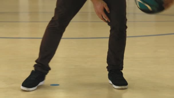 Молодой человек занимается баскетбольным дриблингом — стоковое видео