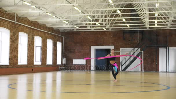 Привлекательная гимнастка прыгает с ленты — стоковое видео