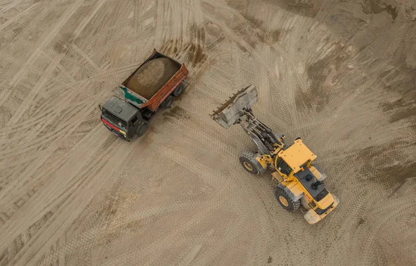 トラックに砂を注ぐブルドーザーの航空写真 — ストック写真
