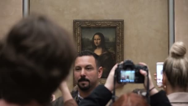 Návštěvníci fotografovat Leonardo Davincis "Mona Lisa" v muzeu Louvre — Stock video