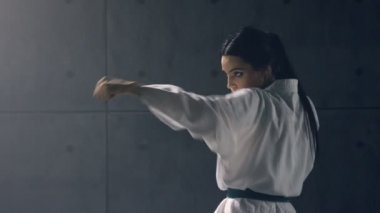 Kimonolu genç kadın karate çalışıyor.