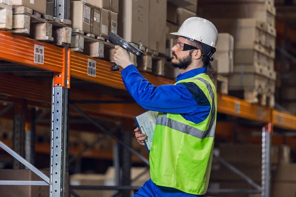 Mann kontrolliert Ladung in Regalen mit Scanner — Stockfoto