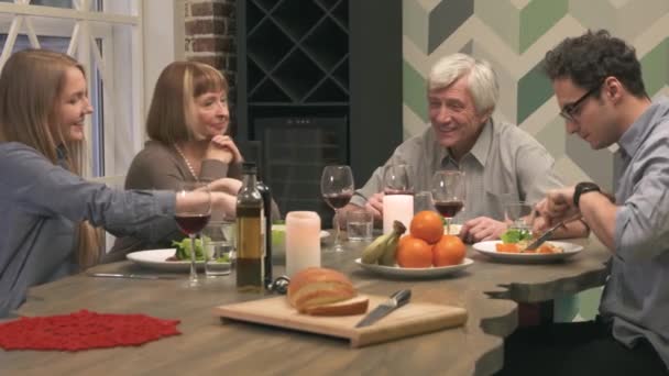 Familia alegre se comunica en la mesa de la cena — Vídeos de Stock
