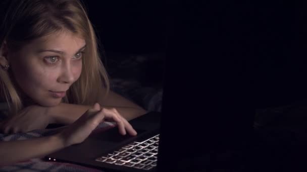 Giovane donna che utilizza il computer portatile a letto — Video Stock