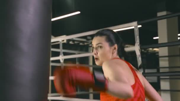 Jeune femme frappant un sac de boxe — Video