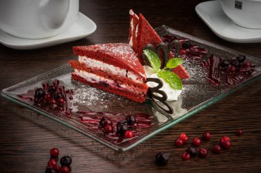 Güzel servis edilmiş kırmızı beyaz pasta, cam bir tabakta, böğürtlenli.