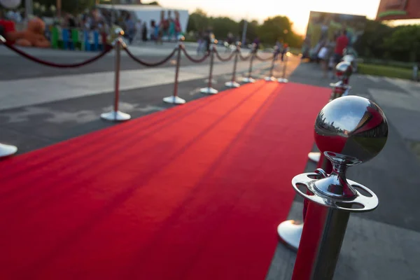 Langer roter Teppich zwischen Seilbarrieren am Vip-Eingang. — Stockfoto