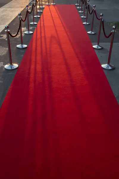 Langer roter Teppich zwischen Seilbarrieren am Vip-Eingang. — Stockfoto