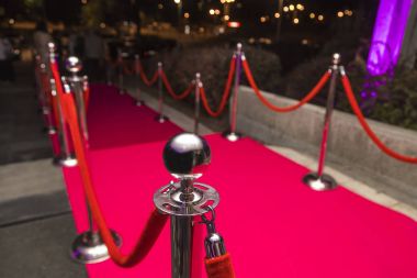 VIP girişi üzerine ip engelleri arasında uzun kırmızı halı.