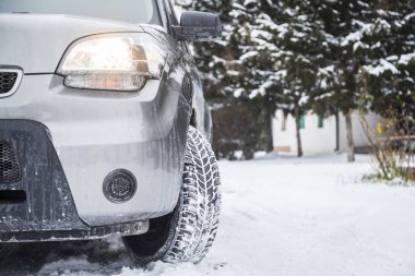 Kış yolundaki araba lastikleri karla kaplı. Araç sabah karlı yolda. 