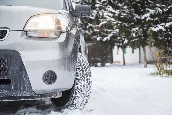 Car tires on winter road covered with snow. Vehicle on snowy way in the morning