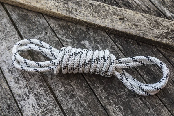 Rope knot on a teak wood background.