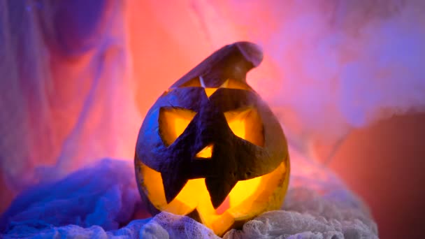 La cabeza de una calabaza en una iluminación siniestra y espectacular, calabaza struetsya humo místico . — Vídeos de Stock