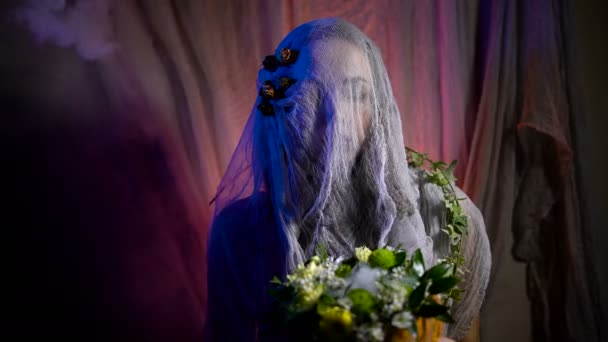 Halloween-Hexe mit einem magischen Kürbis im Dunkeln. schöne junge Frau in Hexenhut und Kostüm mit geschnitztem Kürbis. — Stockvideo