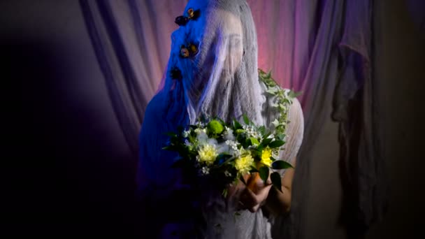 Bruja de Halloween con una calabaza mágica en una oscuridad. Hermosa joven con sombrero de brujas y traje que sostiene calabaza tallada . — Vídeos de Stock