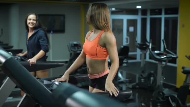 Two fit girls on treadmills — Stock Video