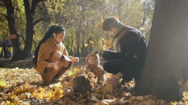 Mutlu aile ile sonbahar oynarken parkta bıraktı. Annem ve babam leas hava atmak. Küçük çocuk bakmak onları ve eğlence.