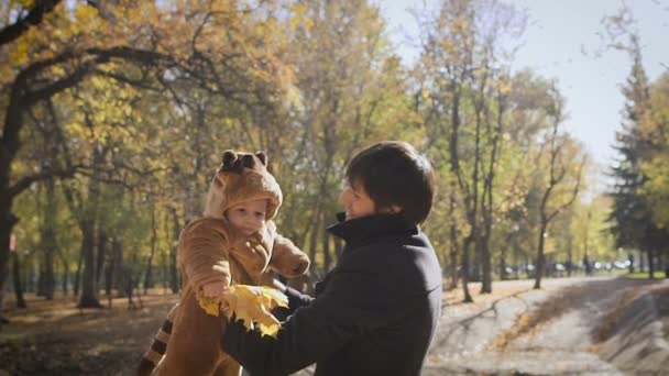 Счастливая семья Отец бросает ребенка сына на прогулку в осенний листок осенью осенью осенью в парке . — стоковое видео