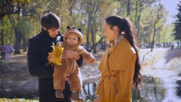 Jovens pais com uma criança na floresta junto à lagoa . — Vídeo de Stock