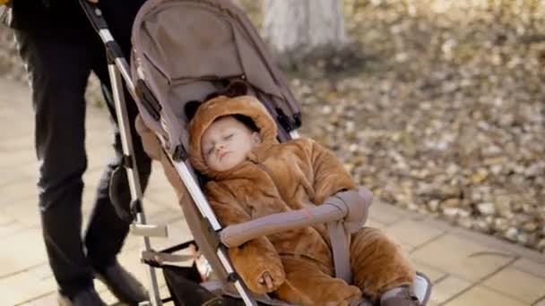 I genitori camminano in città nel caldo autunno con il bambino . — Video Stock