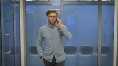 Uzun bir koridor ve telefonda konuşurken Office yöneticisidir