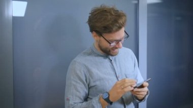 Cep telefonu üzerinde gülümseyen genç adam manifatura