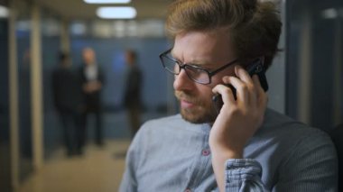 Ofis çalışanı lobide onun smartphone üzerinde konuşuyor.