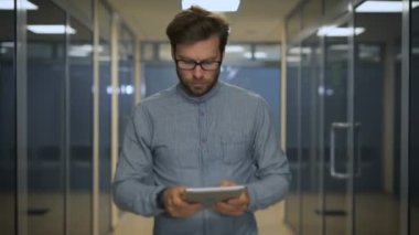 Ofis Yöneticisi ofiste dar bir koridor boyunca çalışır ve tablet bilgisayarınız not edin.