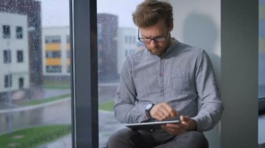 Üniversite sınavı sonucunu bekleyen koridorda pencere üzerinde oturan bir öğrenci