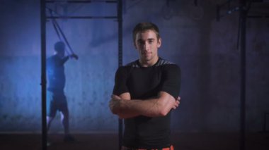 İçinde siyah spor giyim giyinmiş genç crossfit atlet kameraya benziyor.
