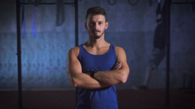 Spor salonunda poz silah ile mavi tişörtlü güçlü adam geçti.