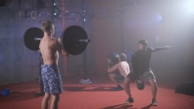 İş grubu crossfit terbiye salonunda beş güçlü sporcular.