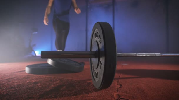 Young athlete coming to the barbell, and adds to it the weight. — Stock Video