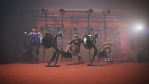 Трое спортсменов занимаются кардио-кроссфитом в спортзале . — стоковое видео
