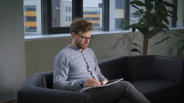 Le patient au centre médical assis sur un canapé et attend de recevoir un médecin . — Video