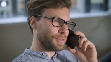 Genç gülümseyen adam portresi konuşmak üstünde onun kız arkadaşı ile hareket eden telefon.