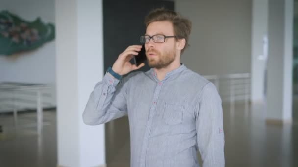 El hombre de negocios se mueve. Conversación telefónica en la oficina . — Vídeos de Stock
