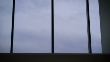 Genç adam panoramik penceresi üzerinde ve sevinir pencerenin dışındaki manzara keyfini