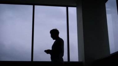Oyunlar cep telefonu karanlık bir odada yürüyen genç adam.