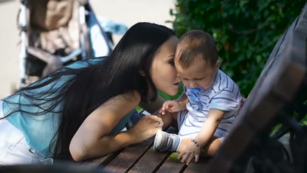 Öpüşme ve küçük çocuğuyla birlikte konuşurken anne — Stok video