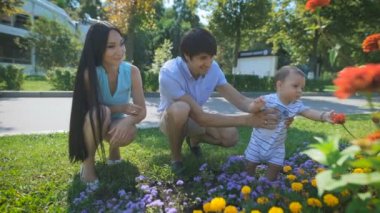 Babası bebeği tutarken için çiçek dokunuyor.