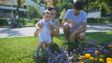 Anne oğluna bir çiçek yatağı göster.