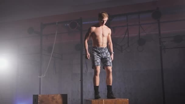 Atleta saludable sin camisa haciendo saltos de caja en el gimnasio . — Vídeo de stock