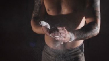 Ağır çekimde spor salonunda crossfit eğitim yapmak onun avucunda magnesia toz uygulamak ve gidiş güçlü insanın yakın çekim.