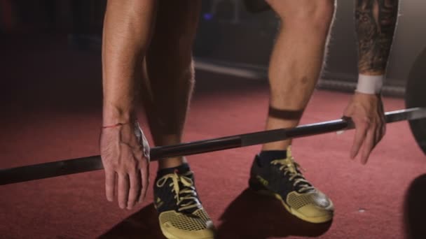 Gros plan sur la prise de l'athlète et la levée de l'haltère à la salle de gym . — Video
