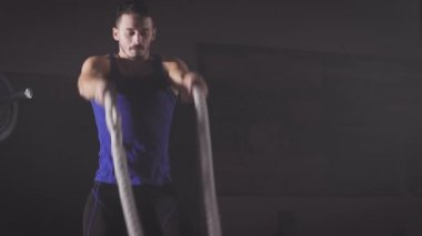 Güç slam ip egzersiz spor yaparak mavi tişörtlü CrossFit adam.