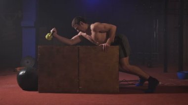 Kutusunda pazı egzersiz yaparak, güç bir sürü almak ve bir lokomotif gibi şişirme seksi kas gömleksiz adam.